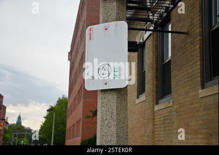 Panneau de rue Boston avec fond blanc délavé et bordure noire. Un symbole d'un œil visible à l'intérieur d'un triangle avec des billets d'un dollar et un œil vert ben Banque D'Images