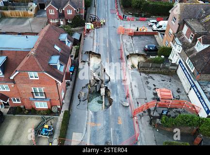 La scène à Godstone après un gouffre est apparue lundi soir. Le grand gouffre a forcé la fermeture de la rue principale dans le village de Surrey. La police de Surrey a déclaré mardi que Godstone High Street était fermée entre Oxted Road et Bletchingley Road. La Force a ajouté qu'un petit nombre de bâtiments avaient été évacués par mesure de précaution et qu'un cordon de 100 mètres avait été mis en place. Date de la photo : mardi 18 février 2025. Banque D'Images