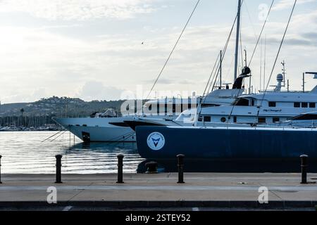 Denia, Espagne - 21 septembre 2024 : des yachts de luxe sont amarrés dans une baie calme, baignée dans la douce lumière de l'aube, créant une atmosphère tranquille et sereine Banque D'Images