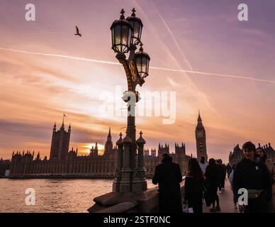 Londres, Royaume-Uni. 18 février 2025. Le Parlement et le pont de Westminster, avec ses lampadaires ornés, sont baignés par une douce lumière du soir tandis que les navetteurs rentrent chez eux. Une journée de beau soleil avec un ciel bleu mais des températures froides se termine dans la capitale. Crédit : Imageplotter/Alamy Live News Banque D'Images