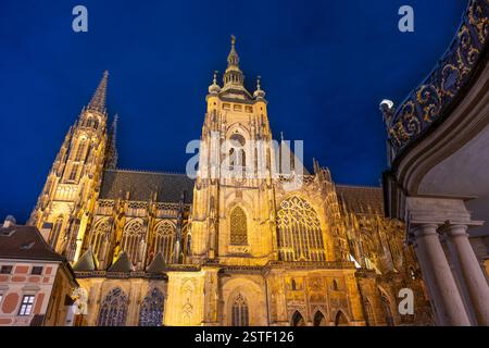 La cathédrale St Vitus se dresse majestueusement sous le ciel nocturne, brillante doucement de lumières dorées. Banque D'Images