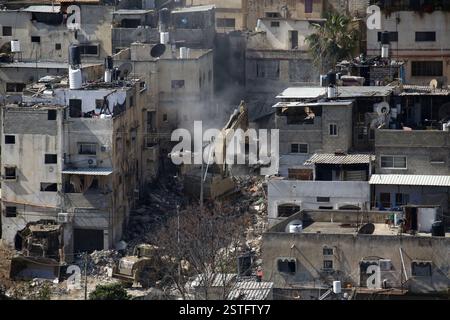 Tulkarm. 18 février 2025. Une excavatrice de l’armée israélienne démolit un bâtiment résidentiel dans le camp de réfugiés de Tulkarem, dans la ville de Tulkarem en Cisjordanie, le 18 février 2025. Crédit : Nidal Eshtayeh/Xinhua/Alamy Live News Banque D'Images