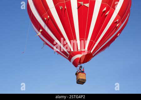 Montgolfière rouge montant dans le ciel. Banque D'Images