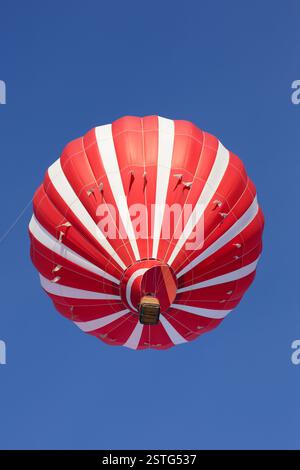 Montgolfière rouge montant dans le ciel. Banque D'Images