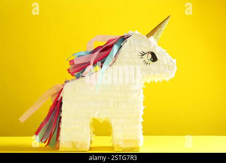 Pinata lumineux en forme de licorne sur fond jaune Banque D'Images