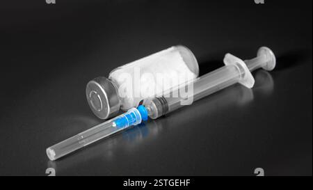 Seringue avec aiguille et coupe sur fond noir, prêt pour l'injection Banque D'Images