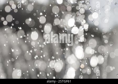 Léviter des gouttes d'eau sur fond sombre dans et hors foyer. Banque D'Images
