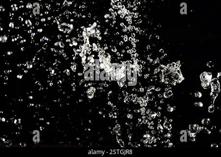 Gouttes d'eau voler dans le ciel avec des lumières de flou artistique en arrière-plan Banque D'Images