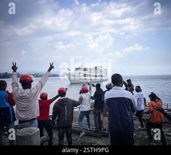 Goma, République démocratique du Congo (RDC). 18 février 2025. Les gens encouragent un ferry approchant d'un quai à Goma, en République démocratique du Congo (RDC), le 18 février 2025. Le trafic sur le lac Kivu entre Bukavu et Goma, deux capitales provinciales de l’est de la République démocratique du Congo (RDC), a repris mardi après des semaines de suspension en raison d’affrontements à Goma. POUR ALLER AVEC 'la circulation reprend sur le lac Kivu au milieu des avancées du M23 en RD Congo' crédit : Zanem Nety Zaidi/Xinhua/Alamy Live News Banque D'Images