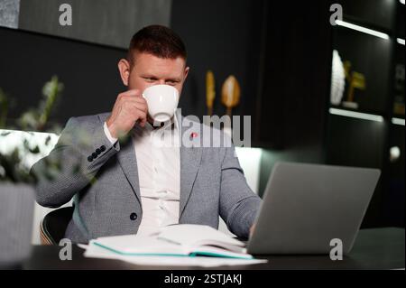 Occupé sérieux homme d'affaires professionnel d'âge moyen investisseur financier, homme d'affaires exécutif portant costume à l'aide d'un ordinateur portable travaillant sur l'investissement Banque D'Images