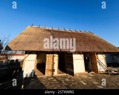 Structure rurale ukrainienne avec un toit de chaume et des portes ouvertes en bois à la lumière du jour Banque D'Images
