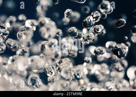 Macro de lévitation des gouttes d'eau sur bleu Banque D'Images