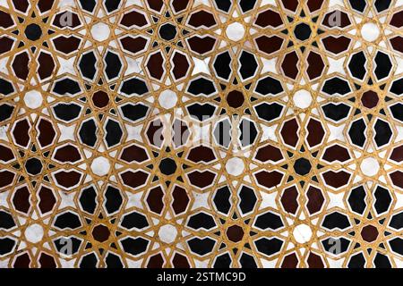 Le mur avant avec des motifs géométriques sur des carreaux de marbre affiche l'art complexe du design islamique, combinant symétrie et élégance dans une belle mosaïque Ar Banque D'Images