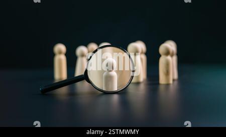 RH, GRH, concept de recrutement en gestion des ressources humaines, poupée en bois et loupe sur fond sombre, concept de travail d'équipe, développement humain Re Banque D'Images