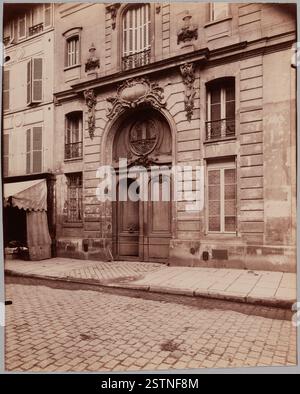 Photographie d’Eugène Atget, prise au début du XXe siècle, représentant une scène de rue parisienne, mettant en valeur les éléments architecturaux et urbains de l’époque. Banque D'Images