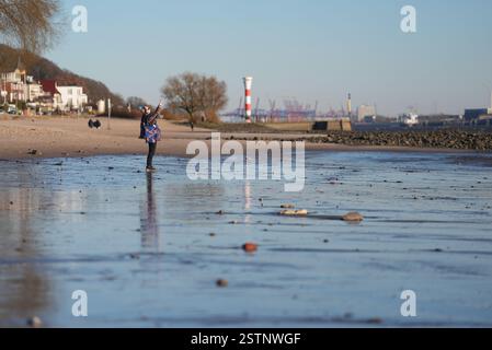 Hambourg, Allemagne. 19 février 2025. Un passant se promène le long de la plage de l'Elbe sous le plus beau soleil. Crédit : Marcus Brandt/dpa/Alamy Live News Banque D'Images