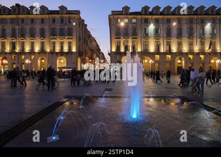 Turin, Italie. Piazza Castello la nuit avec fontaine et jeux d'eau colorés. Rue animée et bâtiments historiques dans le centre de Turin. 2024-11-02 Banque D'Images