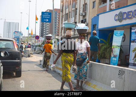 Les vendeurs de routes à Abidjan, en Côte d’Ivoire, sont l’une des entreprises risquées que les immigrants utilisent pour faire leur mode de vie en Afrique de l’Ouest. Dissiper le danger Banque D'Images