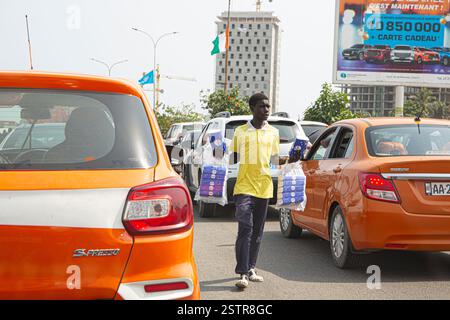 Les vendeurs de routes à Abidjan, en Côte d’Ivoire, sont l’une des entreprises risquées que les immigrants utilisent pour faire leur mode de vie en Afrique de l’Ouest. Dissiper le danger Banque D'Images