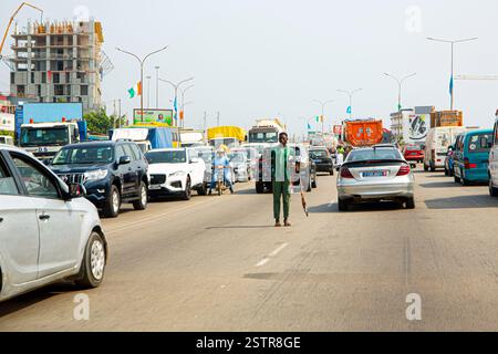 Les vendeurs de routes à Abidjan, en Côte d’Ivoire, sont l’une des entreprises risquées que les immigrants utilisent pour faire leur mode de vie en Afrique de l’Ouest. Dissiper le danger Banque D'Images