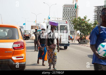 Les vendeurs de routes à Abidjan, en Côte d’Ivoire, sont l’une des entreprises risquées que les immigrants utilisent pour faire leur mode de vie en Afrique de l’Ouest. Dissiper le danger Banque D'Images