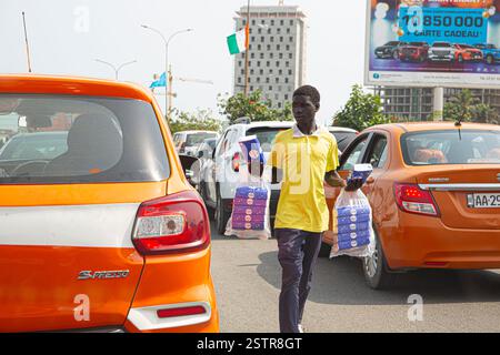 Les vendeurs de routes à Abidjan, en Côte d’Ivoire, sont l’une des entreprises risquées que les immigrants utilisent pour faire leur mode de vie en Afrique de l’Ouest. Dissiper le danger Banque D'Images