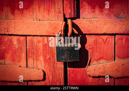 Serrure fermée sur les portes en planches de bois et peintes en rouge, rétro Banque D'Images