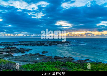 Un lever de soleil venteux sur la mer depuis Soldiers Beach à Norah Head, NSW, Australie. Banque D'Images