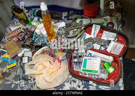 Ukraine, Romny, 21 octobre 2024 : une table désordonnée remplie de divers médicaments, cosmétiques, produits de soins personnels, câbles et objets divers, c Banque D'Images
