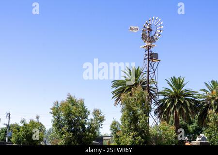 L'emblématique moulin à vent en métal utilisé pour pomper l'eau souterraine dans des réservoirs de rétention élevés pour la pression de l'eau. Banque D'Images