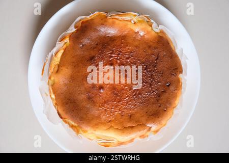 Gros plan de cheesecake basque brûlé maison sur une assiette blanche. Banque D'Images