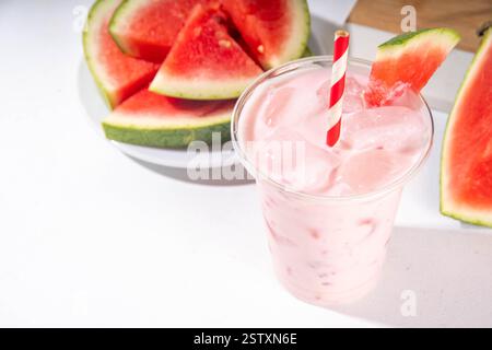 Délicieux milkshake sucré à la pastèque ou cocktail de slushie crémeux, garni de tranche de pastèque dans une tasse en plastique, espace de copie Banque D'Images