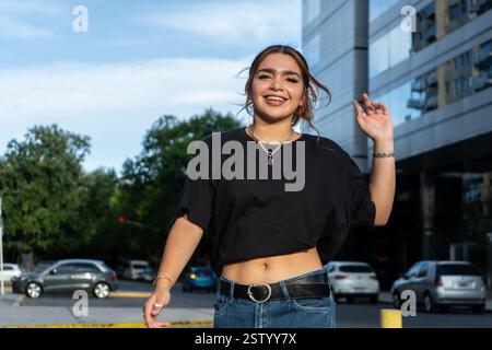 Jeune femme confiante souriante dans un environnement urbain moderne Banque D'Images