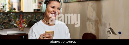 Une jeune femme sourit et profite de sa boisson et de sa musique dans un café très fréquenté. Banque D'Images