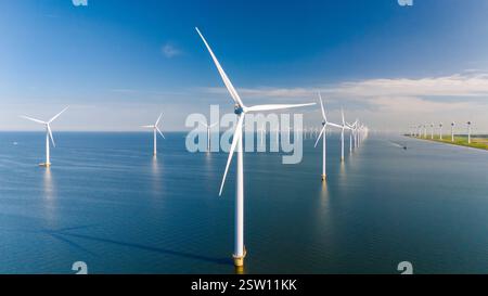 Éoliennes générant de l'énergie renouvelable contre un paysage marin hollandais serein Banque D'Images