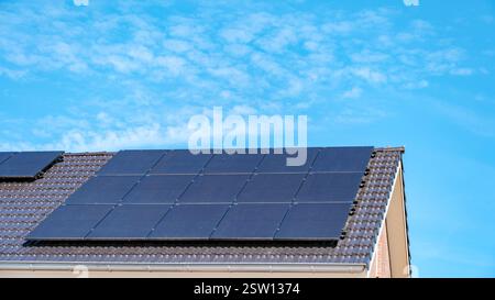 Panneaux solaires utilisant l'énergie solaire sur le toit sous ciel bleu clair Banque D'Images