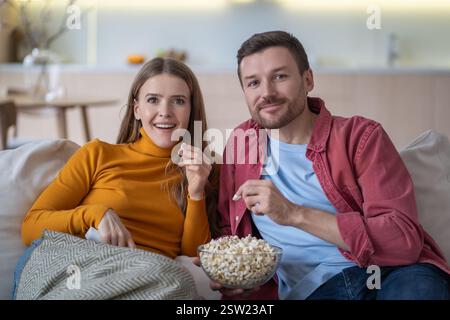 Couple dans l'amour se trouve confortablement canapé, profiter de regarder le film. Homme et femme passant un week-end paresseux. Banque D'Images