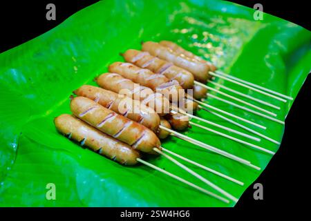 Découpe de saucisse Isan sur feuille de banane sur blanc isolé Banque D'Images
