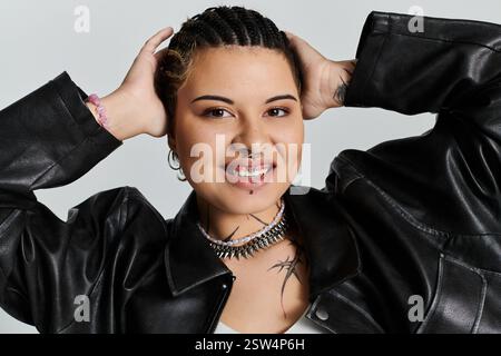 Une jeune femme aux cheveux tressés et aux tatouages audacieux exprime son individualité dans une tenue chic. Banque D'Images