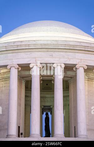 WASHINGTON DC — Une silhouette de profil latéral de la statue de Thomas Jefferson est vue à travers les colonnes du côté ouest du Jefferson Memorial. La statue en bronze de 19 pieds, sculptée par Rudulph Evans, représente le troisième président américain debout avec la Déclaration d'indépendance dans sa main. Le mémorial néoclassique, conçu par l'architecte John Russell Pope, crée un encadrement spectaculaire pour la statue emblématique. Banque D'Images