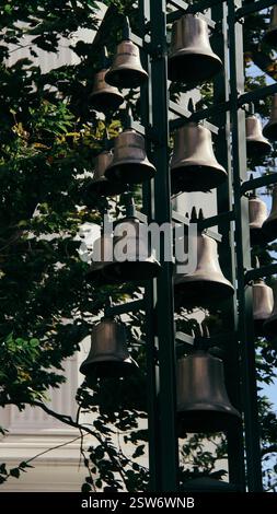 Un ensemble de cloches suspendues à l'extérieur, capturées dans la lumière naturelle avec une atmosphère cinématographique Banque D'Images