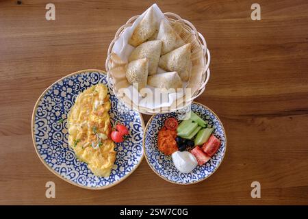 Un délicieux petit déjeuner composé d'une omelette moelleuse, de légumes frais, de pâtisseries salées et d'une trempette crémeuse Banque D'Images