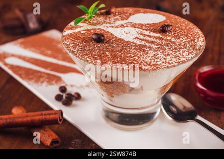 Délicieux dessert tiramisu avec grains de café et bâtonnets de cannelle servis dans une assiette Banque D'Images