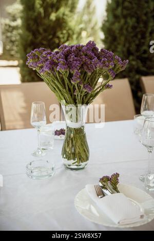 Un verre de vin et un vase de fleurs une table Banque D'Images