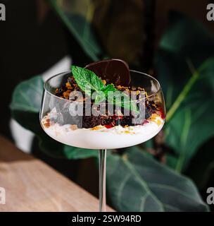 Dessert au chocolat servi dans un verre de fantaisie sur une table Banque D'Images