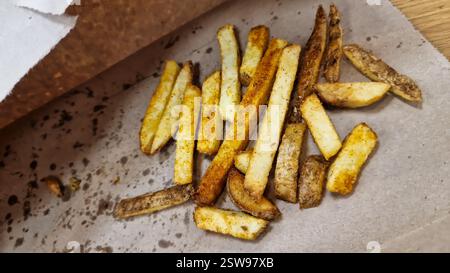 Délicieusement fraîchement cuites frites servies sur une assiette en papier pratique pour le plaisir Banque D'Images