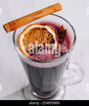Vin chaud dans une tasse en verre avec cannelle et tranche d'orange Banque D'Images