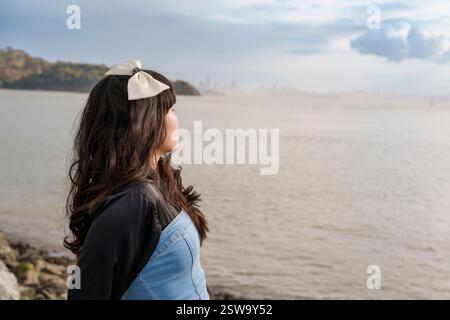 Jeune femme portant Bow San Francisco Bay Cloudy Day Banque D'Images
