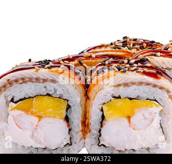 Rouleaux de sushi à l'anguille fumée et à la mangue recouverts de sauce unagi et de graines de sésame Banque D'Images
