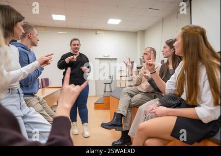 Les jeunes communiquent en langue des signes dans une salle de classe universitaire. Banque D'Images
